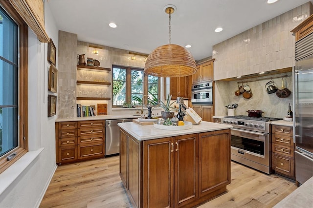 kitchen with pendant lighting, high quality appliances, tasteful backsplash, a center island, and light wood-type flooring