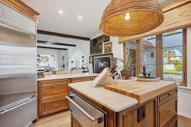 kitchen featuring stainless steel fridge, a center island, and light wood-type flooring