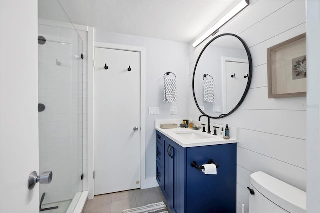 bathroom with tiled shower, tile patterned floors, vanity, and toilet