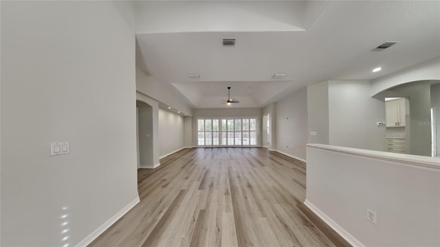 unfurnished living room with a raised ceiling and light hardwood / wood-style floors