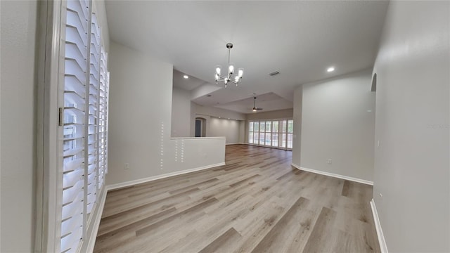 spare room featuring a notable chandelier and light hardwood / wood-style floors