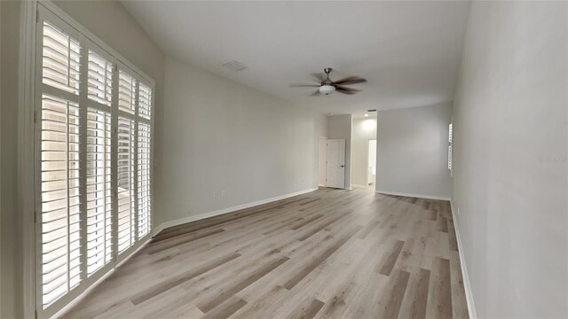 spare room with ceiling fan and light wood-type flooring