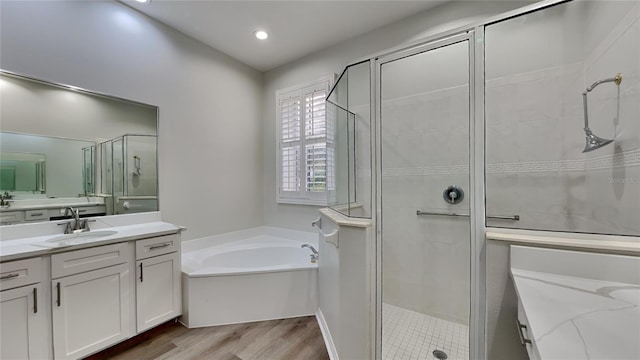 bathroom featuring vanity, wood-type flooring, and separate shower and tub