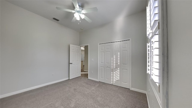 unfurnished bedroom featuring ceiling fan, a closet, and carpet