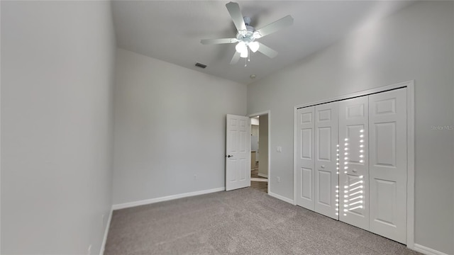 unfurnished bedroom with ceiling fan, light colored carpet, and a closet