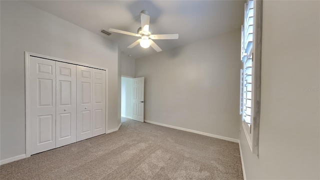 unfurnished bedroom with light colored carpet, ceiling fan, and a closet