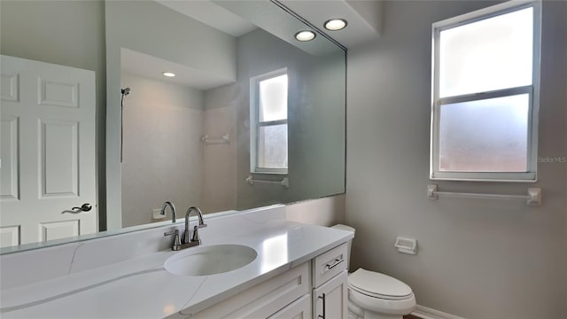 bathroom featuring vanity, toilet, and walk in shower