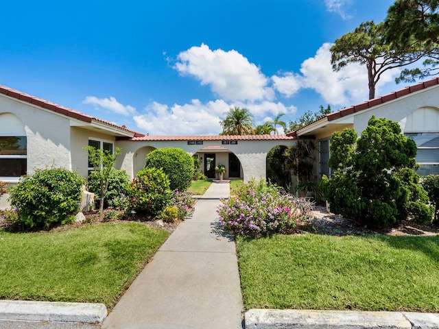 mediterranean / spanish house with a front lawn