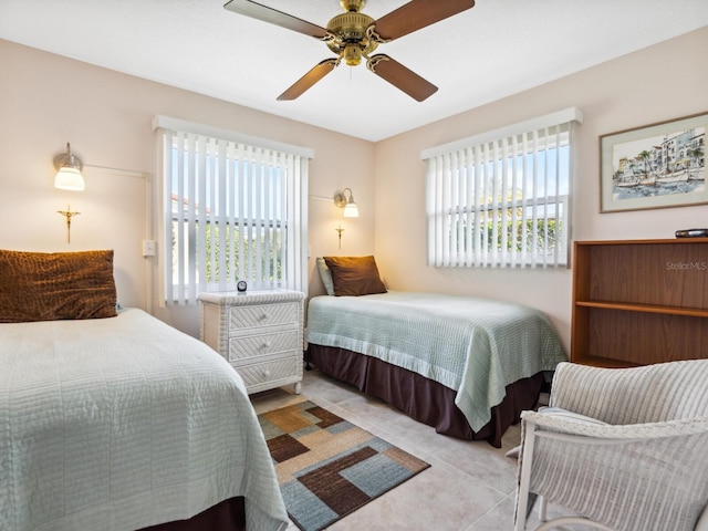 tiled bedroom featuring ceiling fan and multiple windows