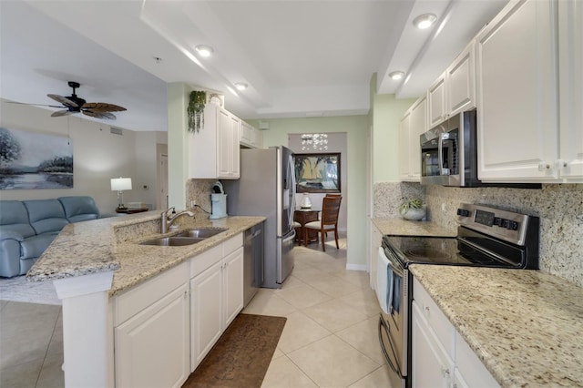 kitchen featuring light tile patterned flooring, sink, appliances with stainless steel finishes, light stone countertops, and white cabinets