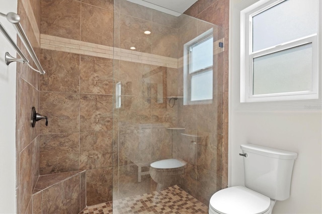 bathroom featuring toilet and tiled shower