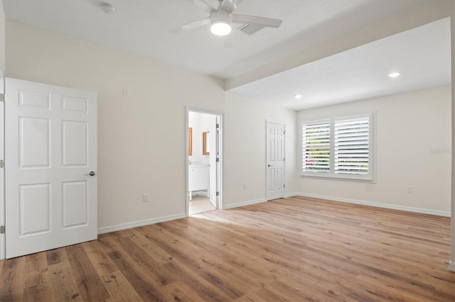 unfurnished bedroom featuring ensuite bath and light wood-type flooring