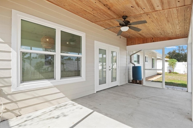 unfurnished sunroom featuring vaulted ceiling, ceiling fan, wood ceiling, and french doors