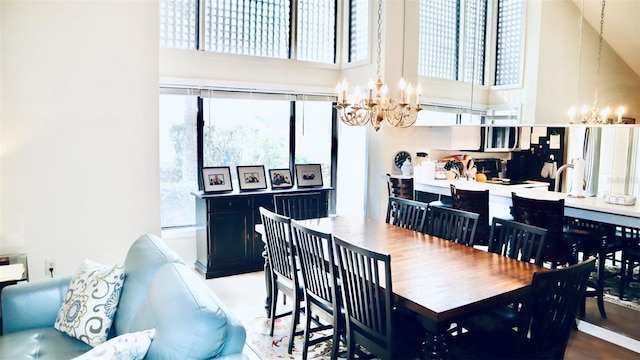 dining space with a towering ceiling and a chandelier