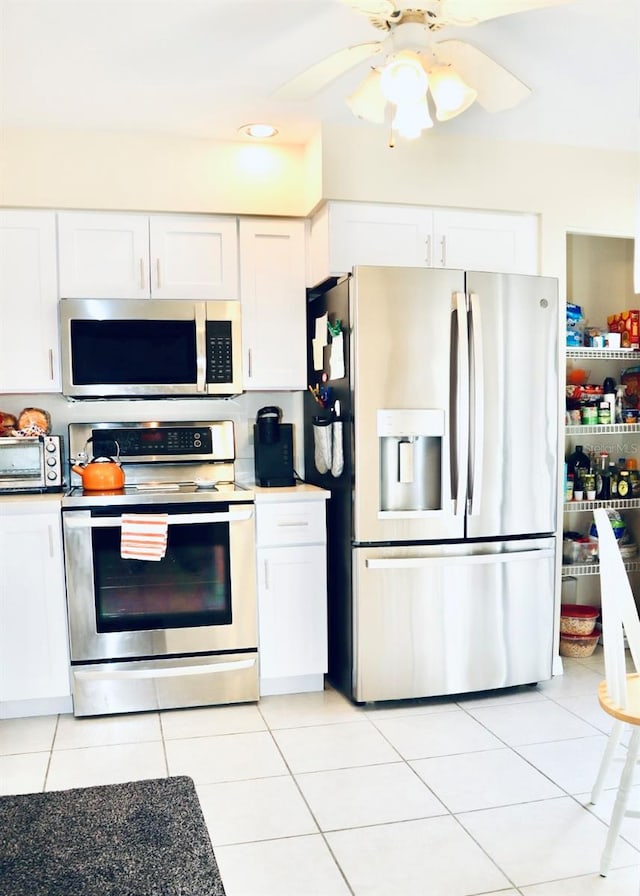 kitchen with white cabinetry, stainless steel appliances, and light tile patterned flooring