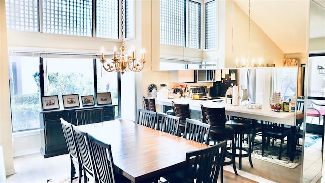 dining room featuring a towering ceiling and an inviting chandelier