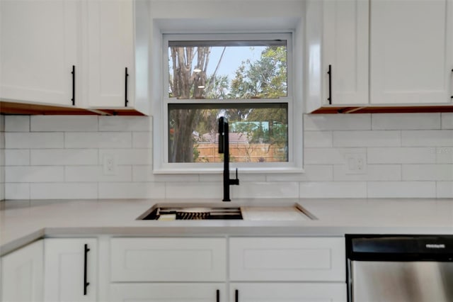 kitchen featuring white cabinetry, sink, backsplash, and stainless steel dishwasher