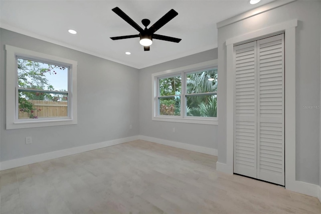 unfurnished bedroom featuring multiple windows, ceiling fan, and a closet