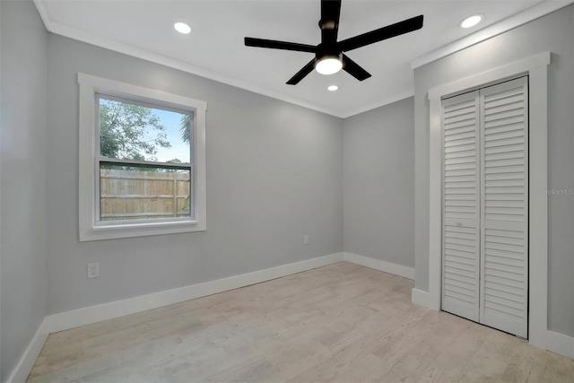 unfurnished bedroom featuring ornamental molding, ceiling fan, light wood-type flooring, and a closet