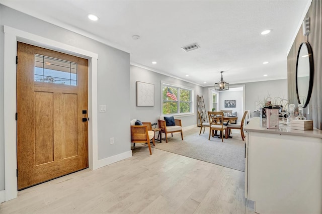 entryway featuring baseboards, recessed lighting, light wood finished floors, and ornamental molding