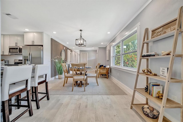 dining room with light wood-style floors, recessed lighting, baseboards, and a chandelier