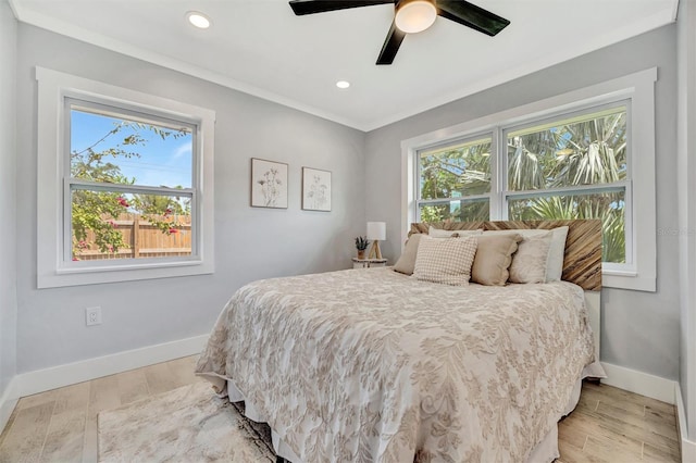 bedroom with multiple windows, baseboards, light wood finished floors, recessed lighting, and crown molding