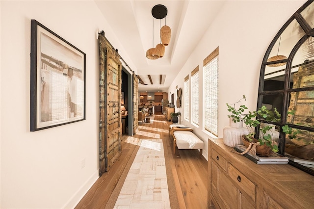 corridor featuring light wood-style flooring and baseboards