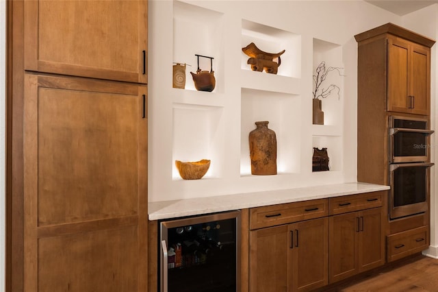 interior space featuring double oven, wine cooler, built in features, and dark wood-style floors