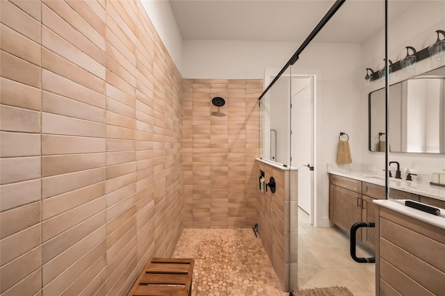 full bathroom featuring tiled shower and vanity