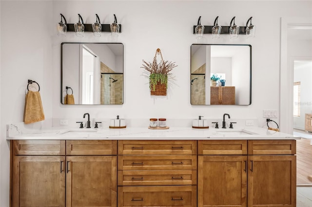 bathroom with double vanity, walk in shower, and a sink