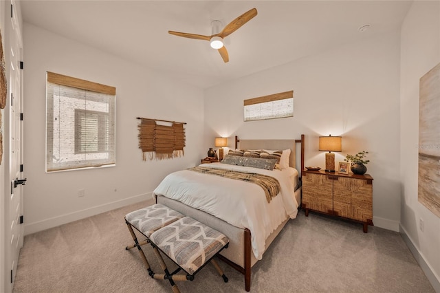 bedroom featuring baseboards, a ceiling fan, and light colored carpet