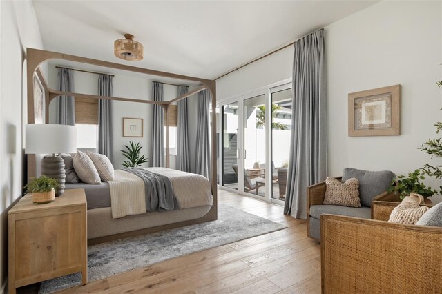 bedroom with light wood-style floors and access to outside