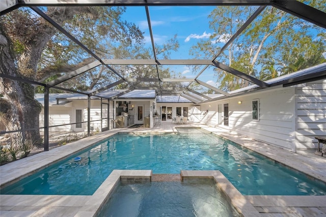 view of swimming pool with an in ground hot tub, a lanai, and a patio