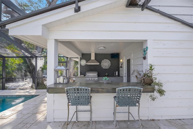 view of patio / terrace with area for grilling, a lanai, and exterior kitchen