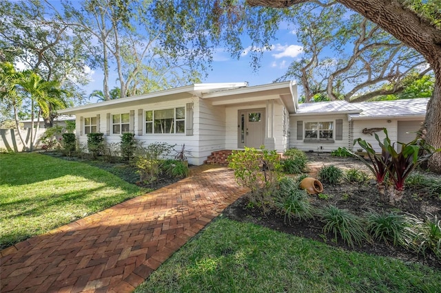 ranch-style house with a garage and a front lawn