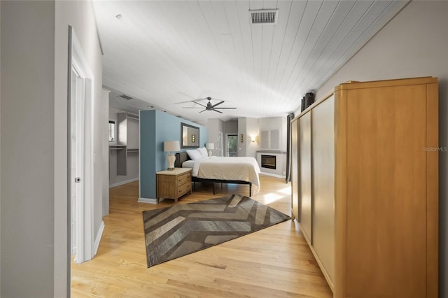 bedroom featuring a barn door, wooden ceiling, and light wood-type flooring