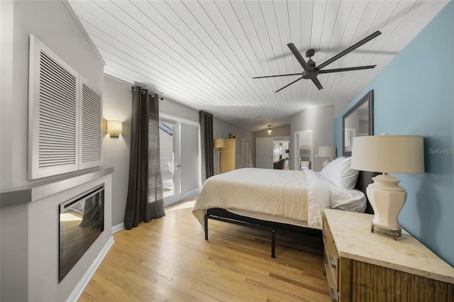 bedroom with a fireplace, access to exterior, ceiling fan, light hardwood / wood-style floors, and wood ceiling