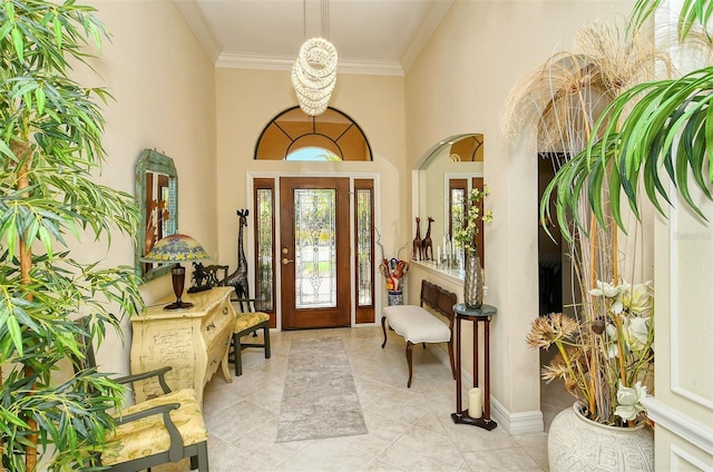 entryway featuring ornamental molding, a high ceiling, and light tile patterned flooring