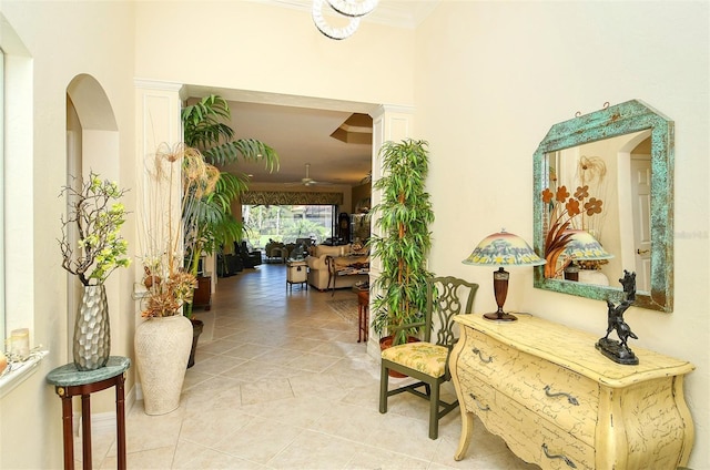 corridor with light tile patterned floors and crown molding