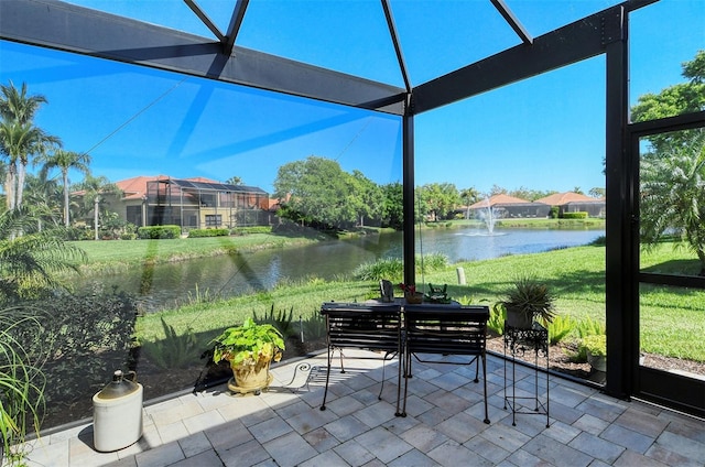 sunroom featuring a water view