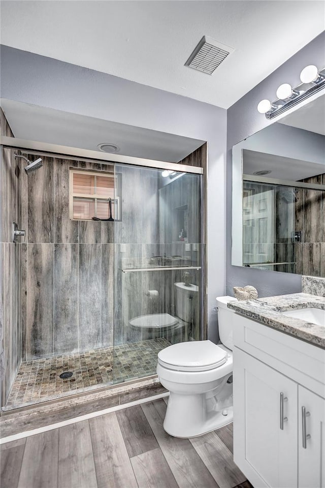 bathroom with vanity, an enclosed shower, wood-type flooring, and toilet