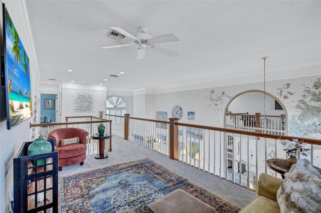 sitting room with crown molding, carpet, and a textured ceiling