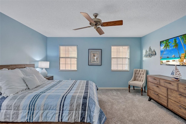 bedroom featuring light carpet, a textured ceiling, multiple windows, and ceiling fan