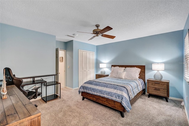 bedroom with light colored carpet, a textured ceiling, ceiling fan, and a closet