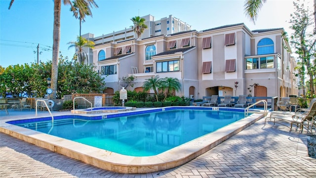 view of pool featuring a community hot tub and a patio area