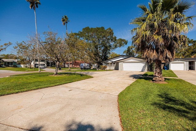 view of front of house with a front yard, concrete driveway, and a residential view