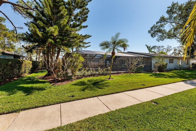 view of front of house featuring glass enclosure and a front lawn