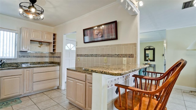 kitchen featuring dark stone countertops, crown molding, and light tile patterned flooring