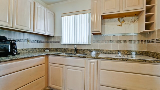 kitchen with stovetop, sink, dark stone countertops, backsplash, and crown molding