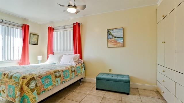 tiled bedroom with ornamental molding and ceiling fan